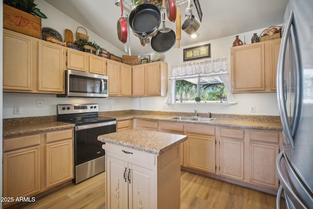 kitchen featuring a center island, lofted ceiling, light brown cabinets, stainless steel appliances, and sink