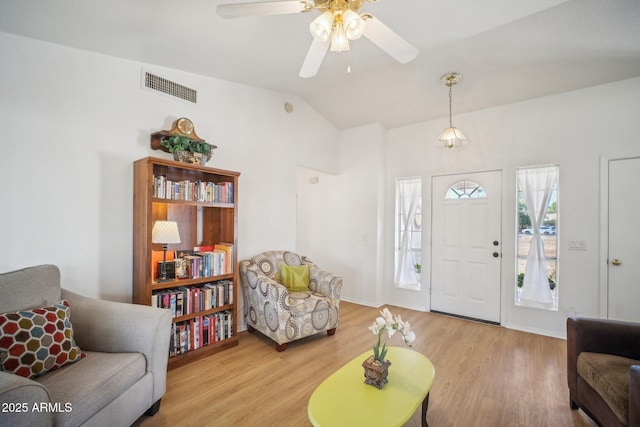 living room with hardwood / wood-style flooring, vaulted ceiling, and ceiling fan