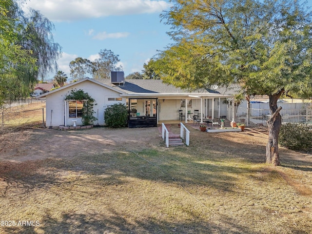 back of property with a lawn, central air condition unit, and a patio