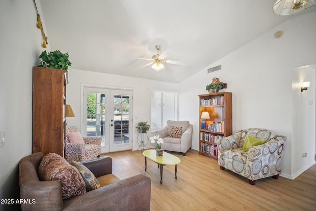 living area with ceiling fan, vaulted ceiling, french doors, and light wood-type flooring