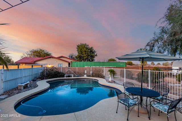 pool at dusk with a patio