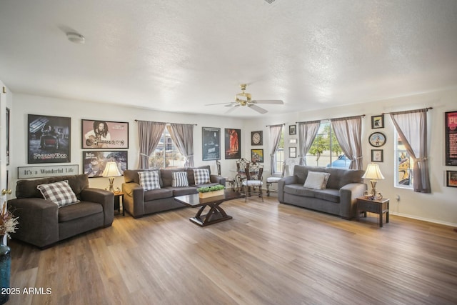 living room with ceiling fan, plenty of natural light, a textured ceiling, and hardwood / wood-style flooring