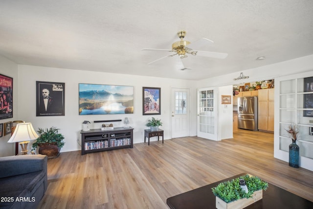 living room with hardwood / wood-style flooring, ceiling fan, a textured ceiling, and french doors