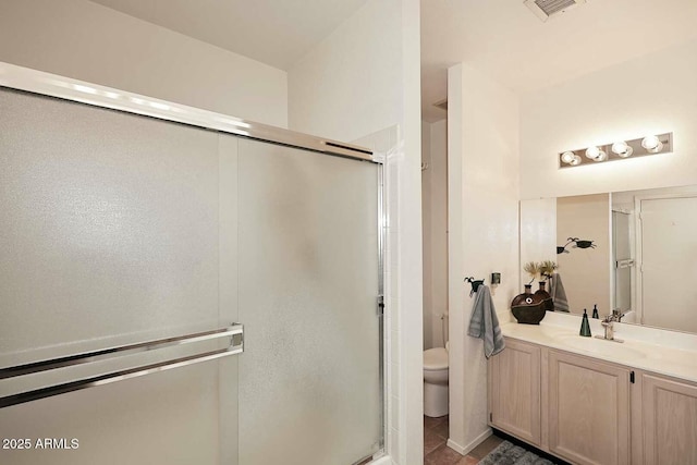 bathroom with toilet, a shower with shower door, and vanity