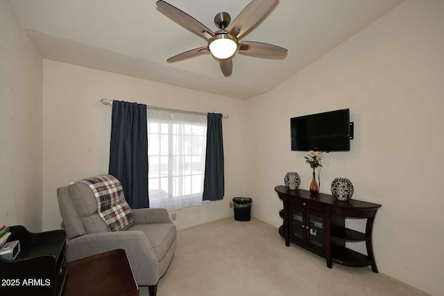 living area with ceiling fan, light colored carpet, and lofted ceiling