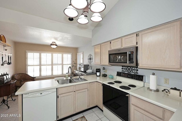 kitchen featuring kitchen peninsula, vaulted ceiling, sink, light tile patterned floors, and white appliances