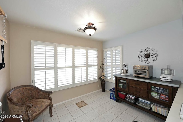 living area with a wealth of natural light and light tile patterned floors