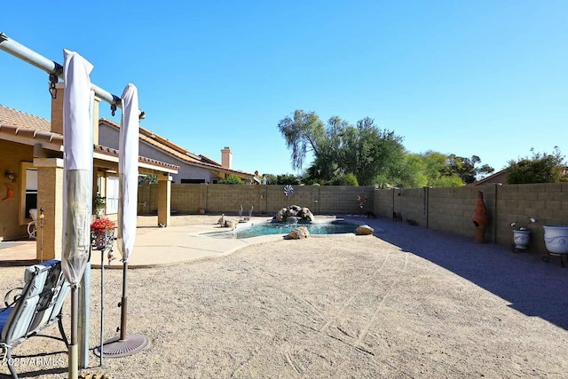 view of yard featuring pool water feature, a fenced in pool, and a patio