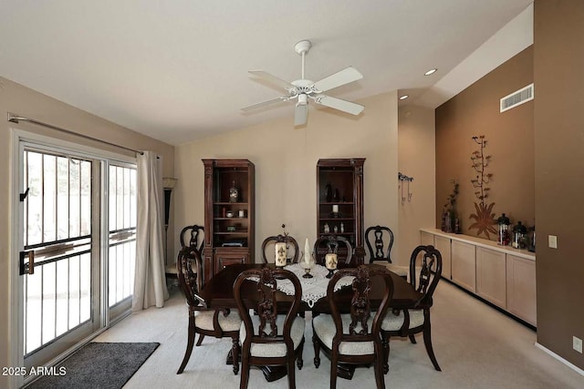 dining space featuring light carpet, ceiling fan, and lofted ceiling