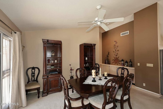 carpeted dining room featuring ceiling fan and lofted ceiling