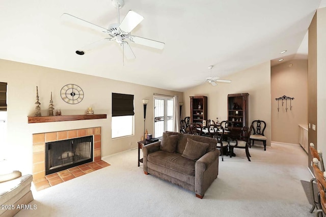 living room with a fireplace, light carpet, vaulted ceiling, and ceiling fan