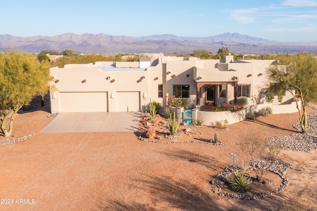 adobe home with a mountain view and a garage