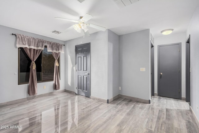 empty room featuring ceiling fan and light wood-type flooring