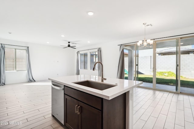 kitchen with hanging light fixtures, a healthy amount of sunlight, sink, and a kitchen island with sink