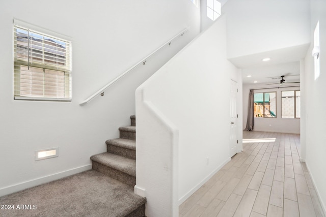 stairway featuring ceiling fan