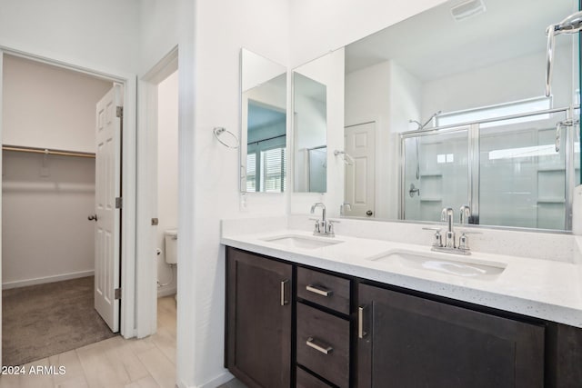 bathroom featuring vanity, toilet, and walk in shower