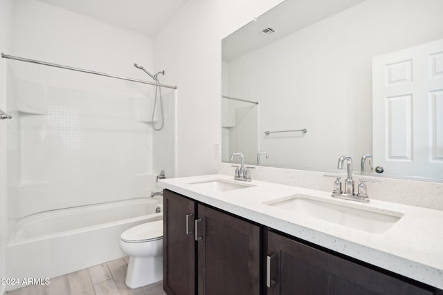 full bathroom with hardwood / wood-style floors, vanity, toilet, and shower / bath combination