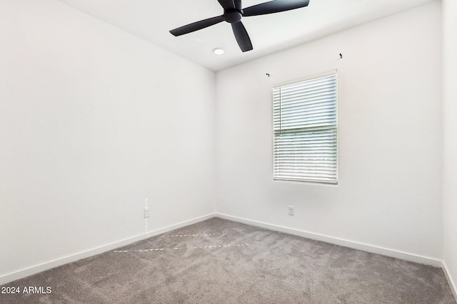 carpeted spare room featuring ceiling fan