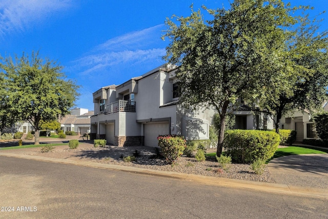 view of front of property featuring a balcony and a garage