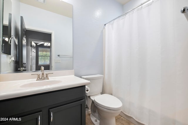 bathroom with walk in shower, vanity, toilet, and tile patterned floors