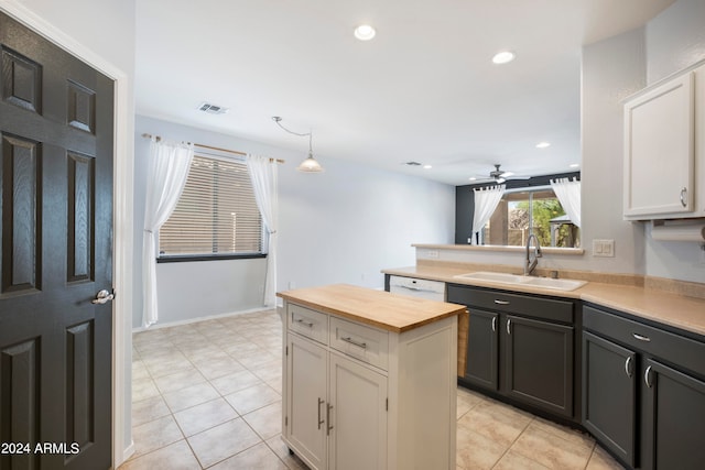 kitchen with white cabinets, ceiling fan, light tile patterned flooring, decorative light fixtures, and sink