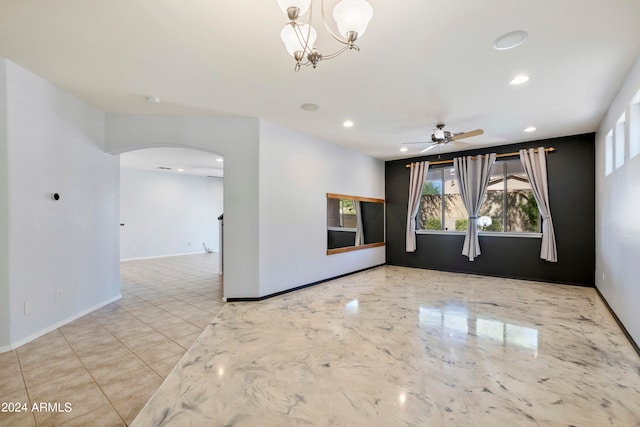 empty room with ceiling fan with notable chandelier