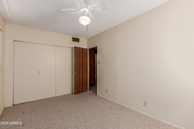 unfurnished bedroom with a ceiling fan, visible vents, carpet floors, a closet, and a textured ceiling