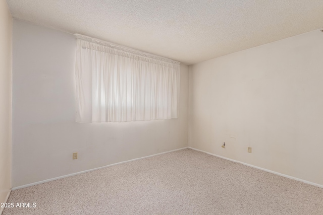 carpeted spare room with baseboards and a textured ceiling