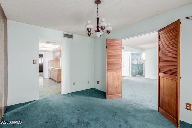 unfurnished dining area featuring a notable chandelier, carpet flooring, visible vents, and a textured ceiling