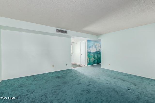 spare room with visible vents, a textured ceiling, and carpet floors