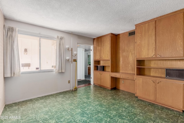 unfurnished living room featuring tile patterned floors, visible vents, baseboards, and a textured ceiling