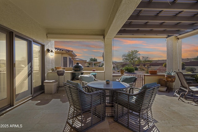 patio terrace at dusk featuring outdoor dining area