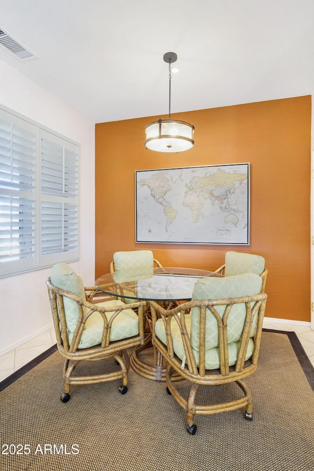 dining area with light tile patterned flooring, visible vents, and baseboards