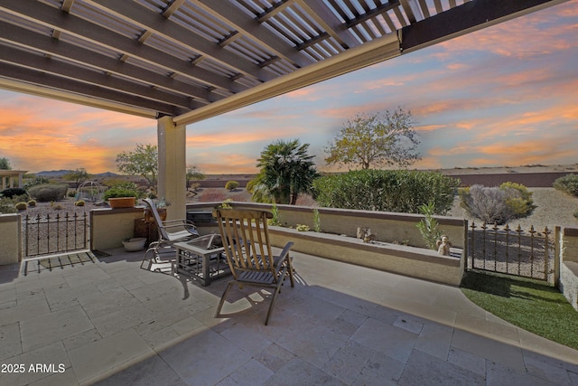 patio terrace at dusk with fence and a pergola