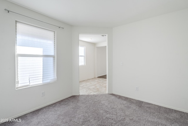 spare room featuring light colored carpet