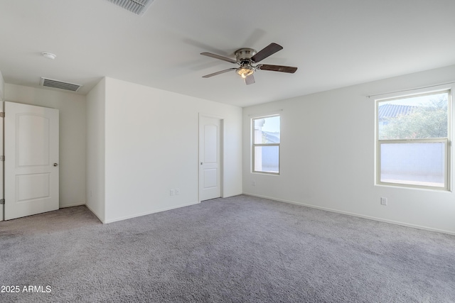 carpeted spare room featuring ceiling fan