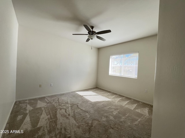 carpeted empty room featuring ceiling fan and baseboards