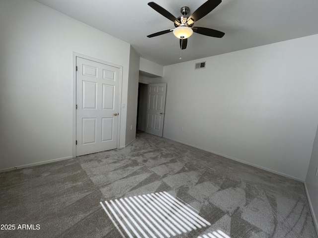 unfurnished bedroom with carpet floors, visible vents, ceiling fan, and baseboards