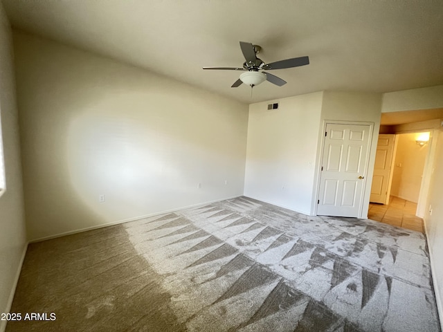 carpeted empty room featuring visible vents and ceiling fan