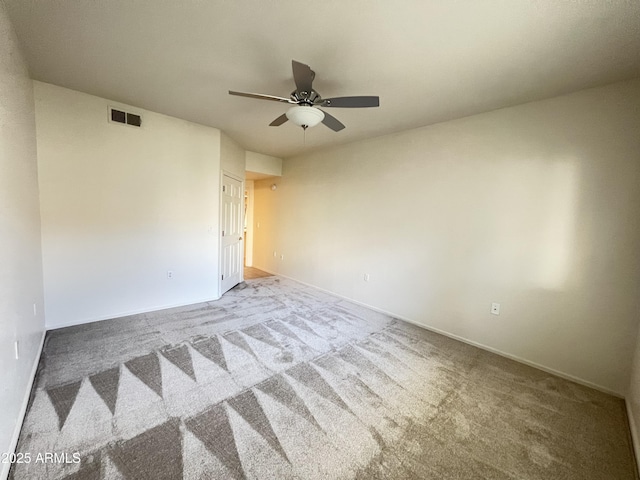 empty room featuring ceiling fan, carpet flooring, visible vents, and baseboards