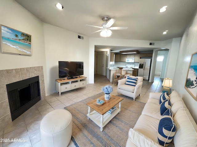 living area with a tile fireplace, visible vents, recessed lighting, and light tile patterned floors