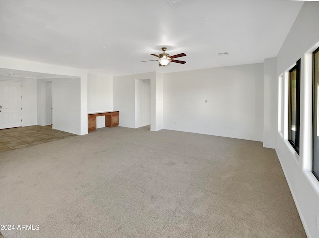 unfurnished living room with light carpet and ceiling fan