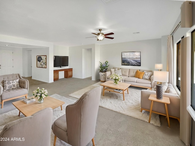 carpeted living room with ceiling fan