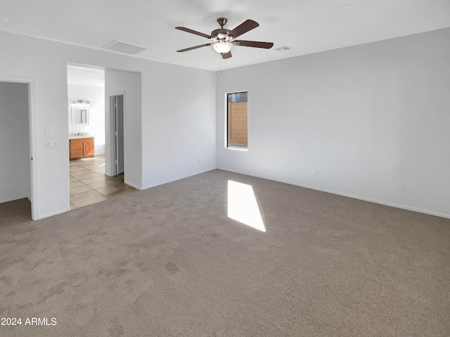 carpeted spare room featuring ceiling fan