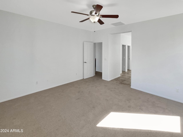 carpeted spare room with ceiling fan