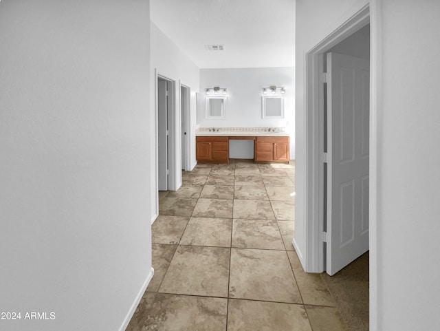 corridor featuring sink and light tile patterned floors