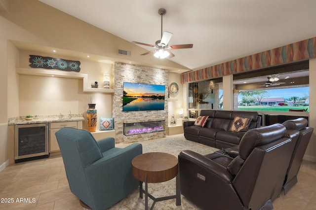 living room featuring a fireplace, vaulted ceiling, beverage cooler, and ceiling fan