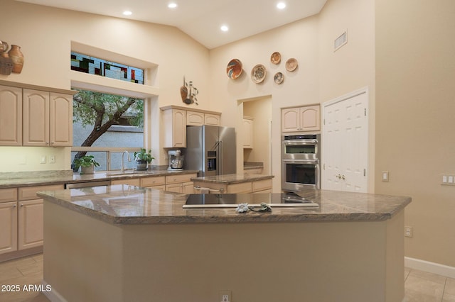 kitchen featuring sink, light brown cabinets, stainless steel appliances, high vaulted ceiling, and a kitchen island