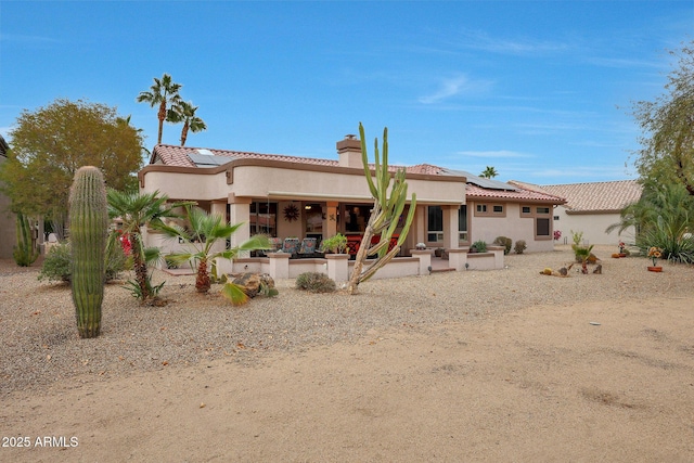 back of house featuring a patio area and solar panels