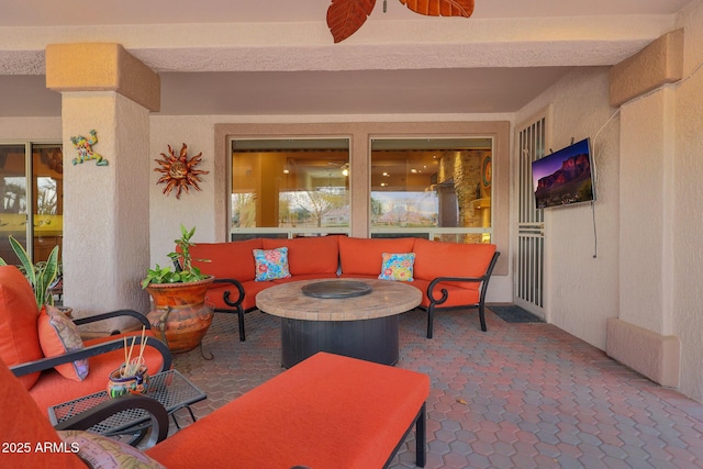 view of patio / terrace featuring ceiling fan and an outdoor living space with a fire pit